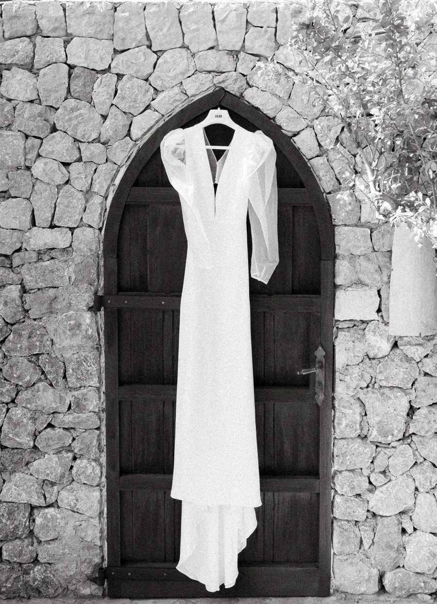 Abito da sposa appeso a una porta ad arco in pietra