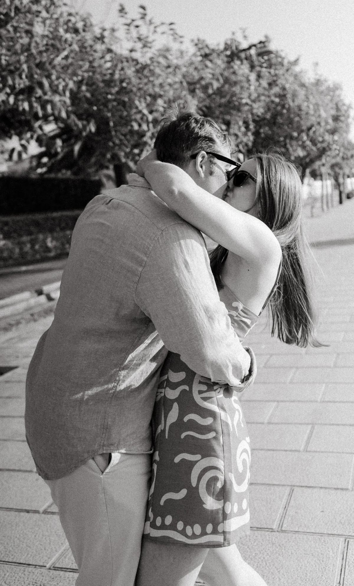 A couple embracing on a street, in black and white