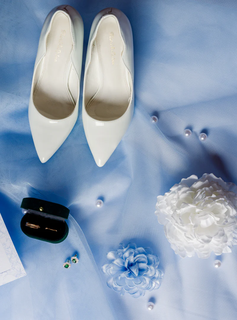 Bridal shoes, rings and pearl details on blue silk