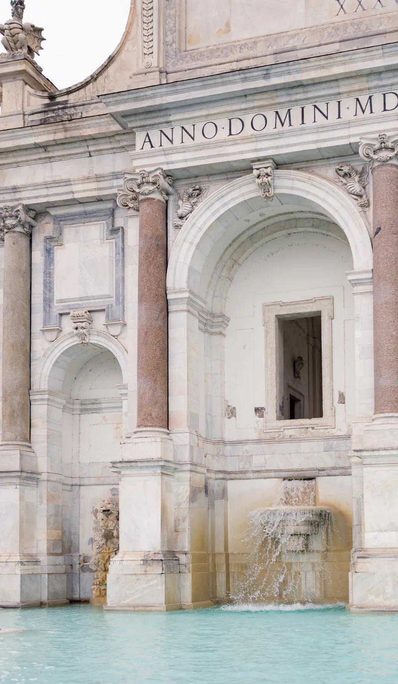 Stone fountain in Rome with a turquoise basin