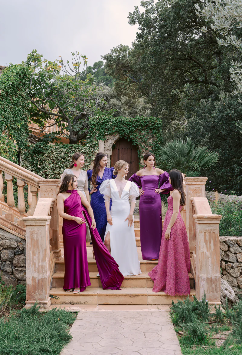 Bridesmaids in jewel tones with the bride on a stone staircase