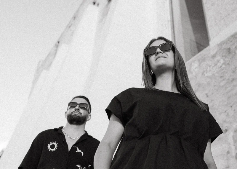 Black-and-white low-angle portrait of a couple in sunglasses