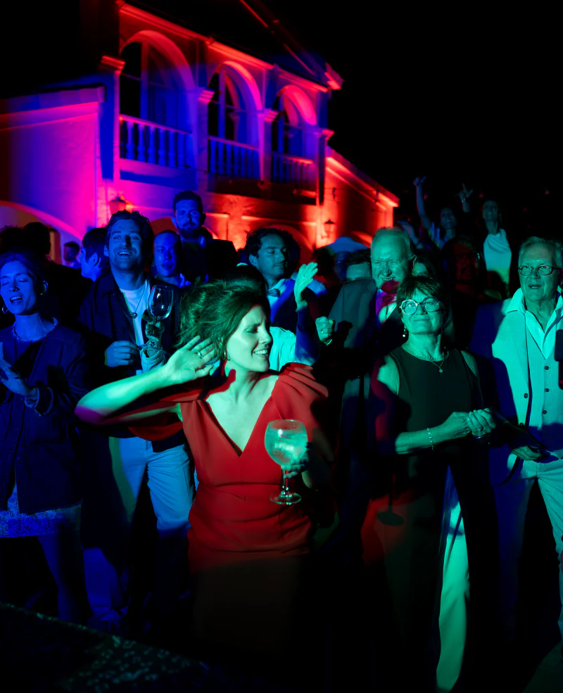 Party guests lit in red and blue at night