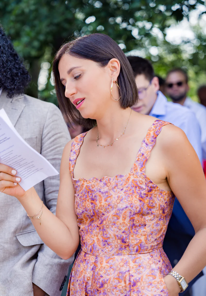 Guest in a floral dress reading the ceremony programme