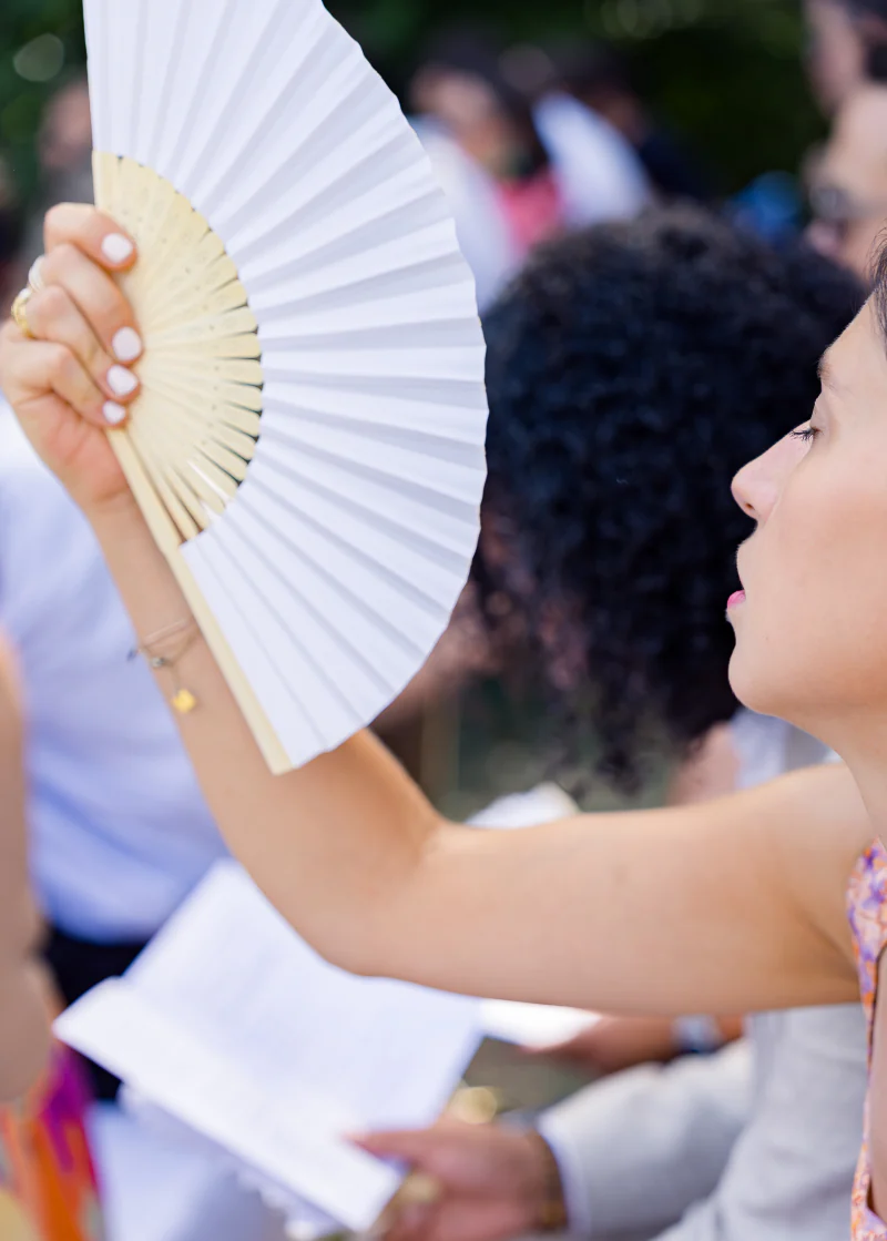 Guest fanning herself during the ceremony