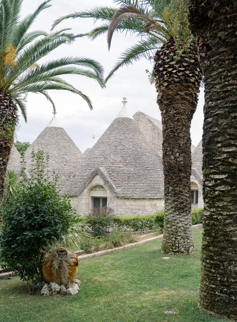 Trulli roofs framed by palm trees in Puglia