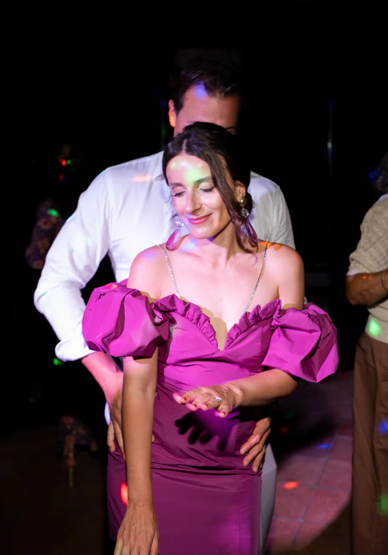 Guest in a magenta dress dancing at night